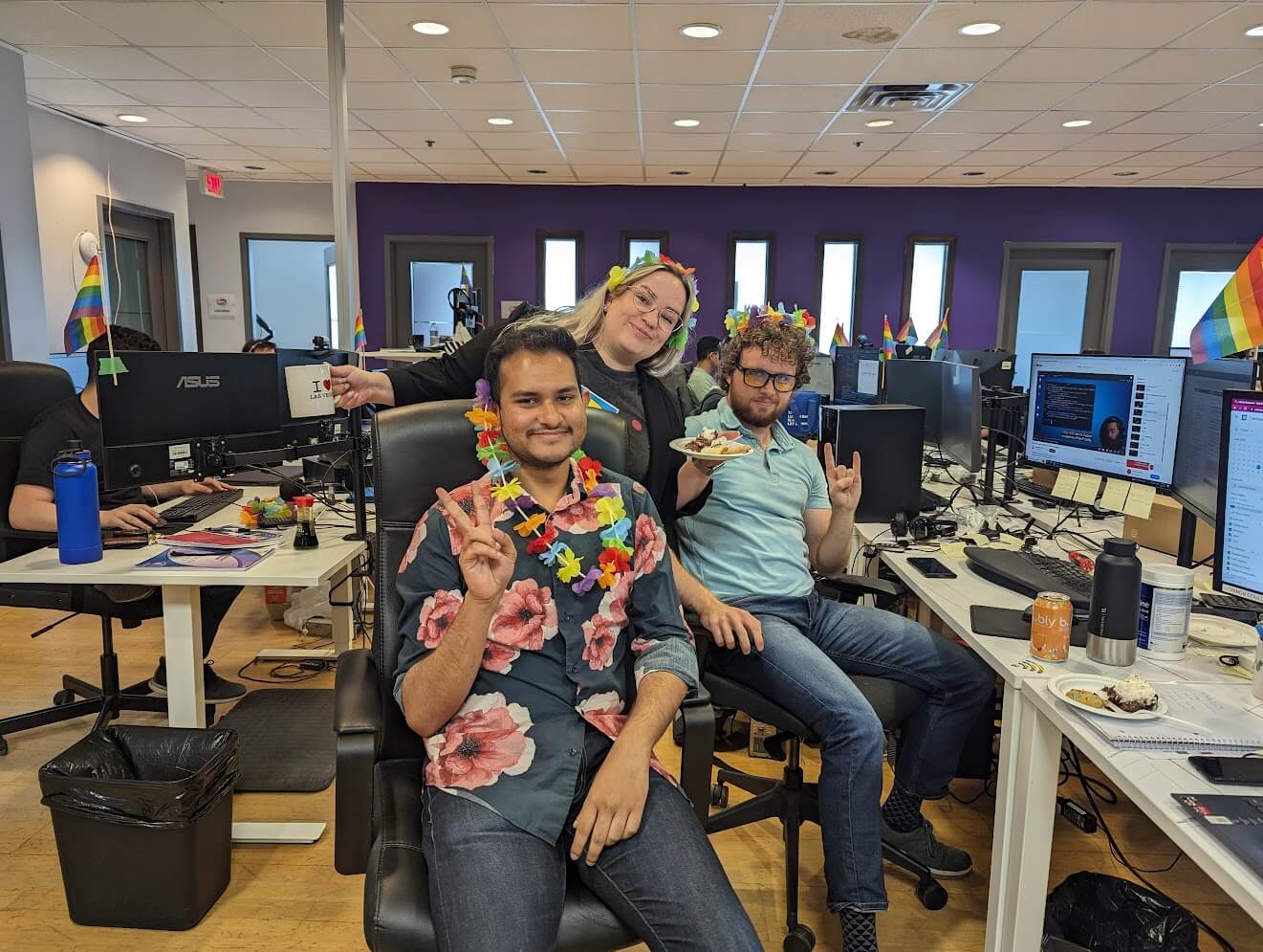 Three three members sit together at a desk, enjoying party.