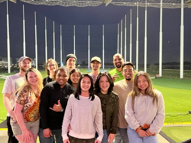 A group of YuJa's team members on a baseball field.