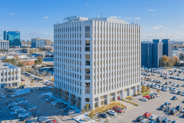 A spacious building with a vast parking lot in front.